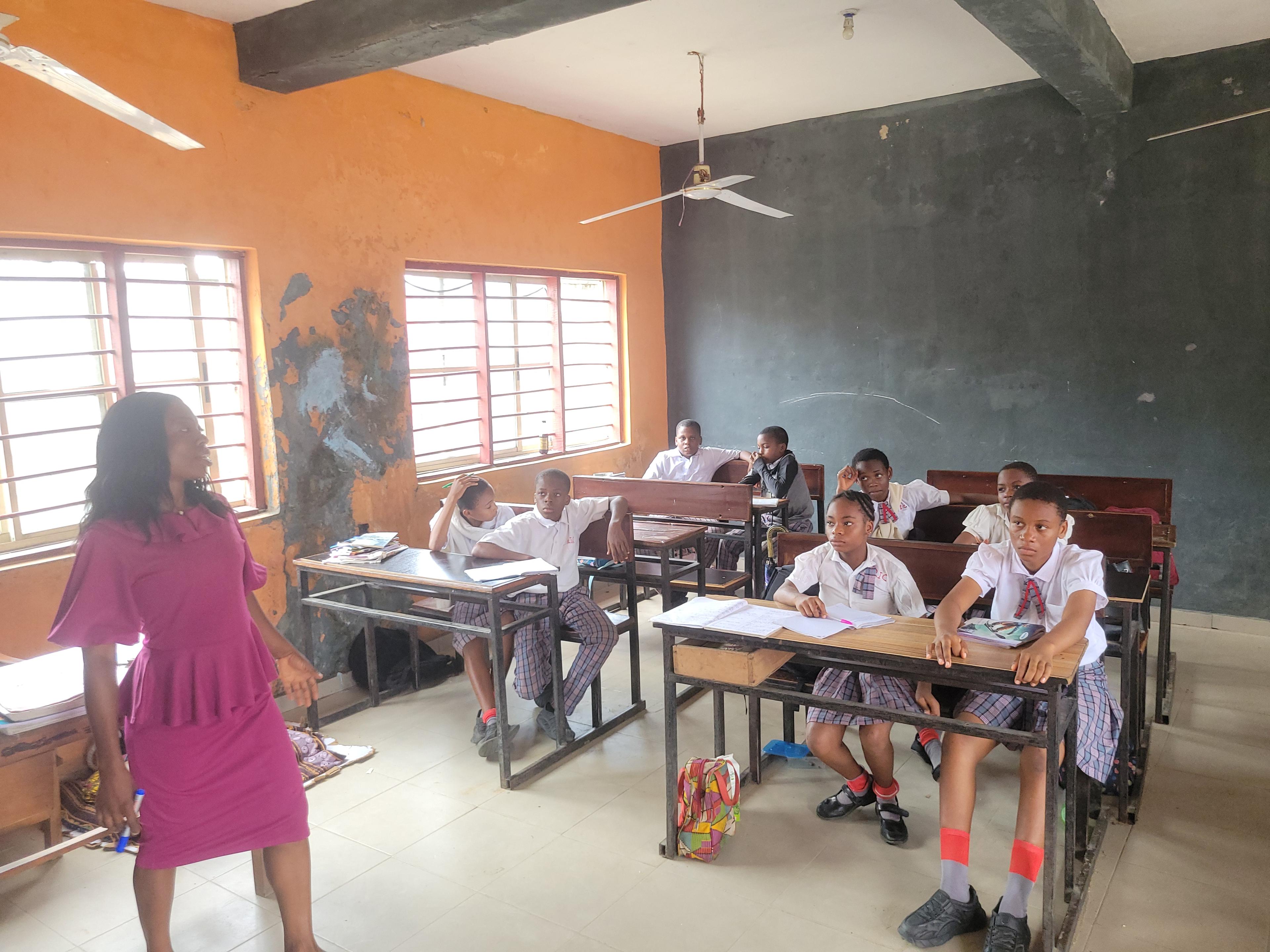 students sitted in a classroom with a teacher teaching